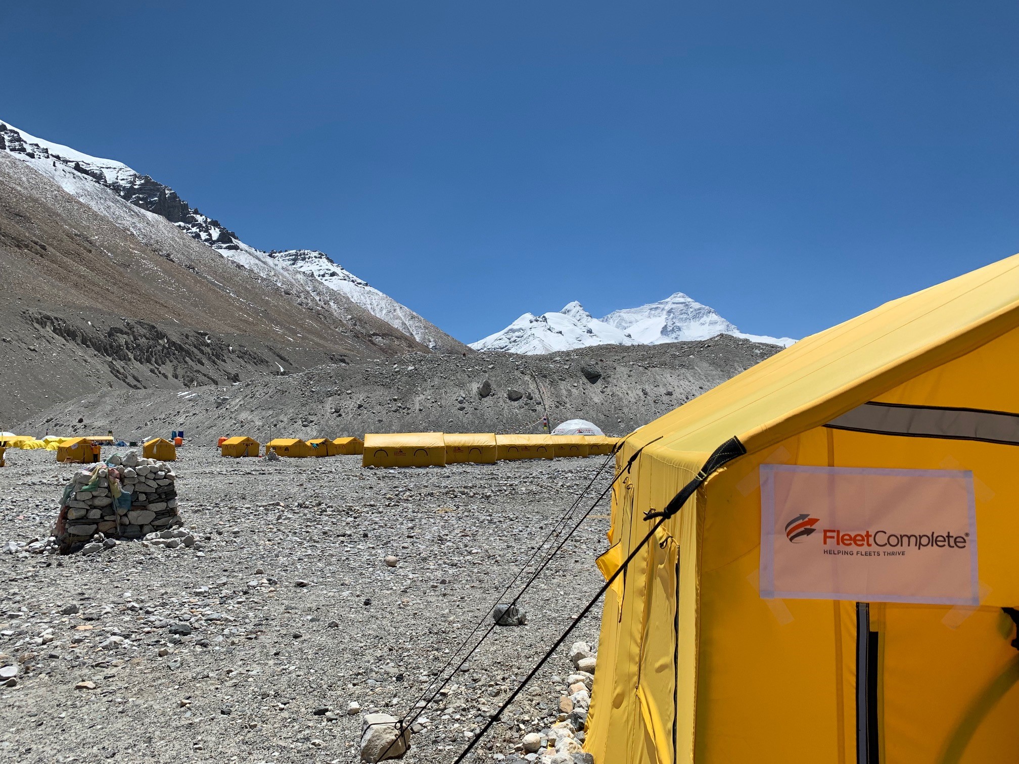 Base camp of Mount Everest with a tent and a Fleet Complete Logo display.