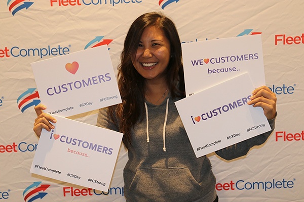 Eloisa holding cards that say we love customers.