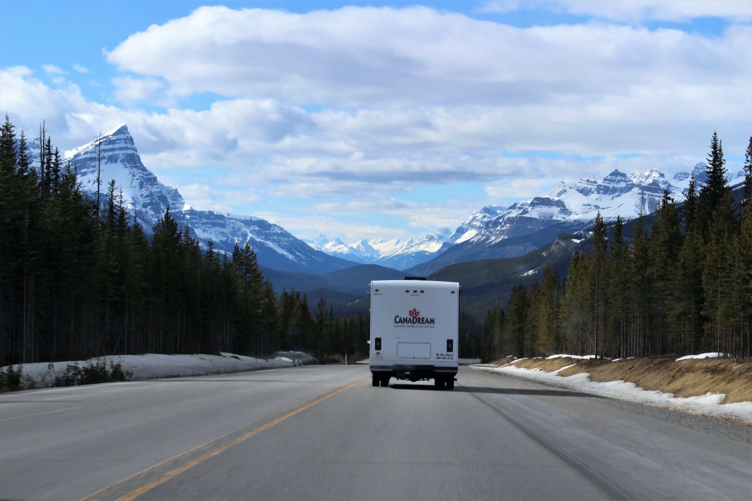 White CanaDream box truck on the road with mountains on background.