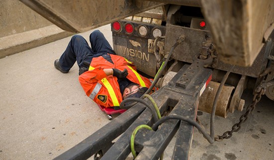 photo of worker carrying out preventative vehicle maintenance